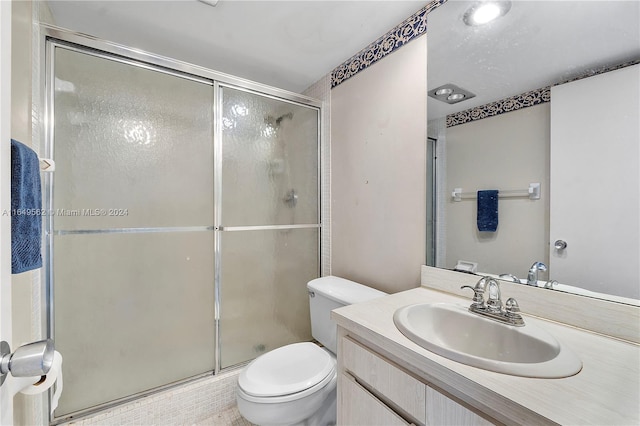 bathroom with vanity, an enclosed shower, and toilet