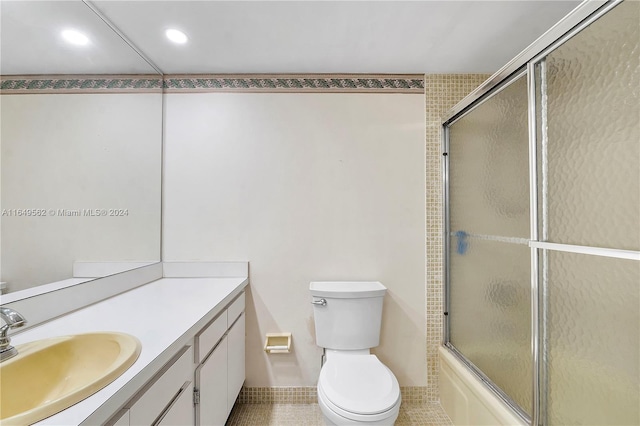 full bathroom featuring tile patterned flooring, toilet, combined bath / shower with glass door, and vanity