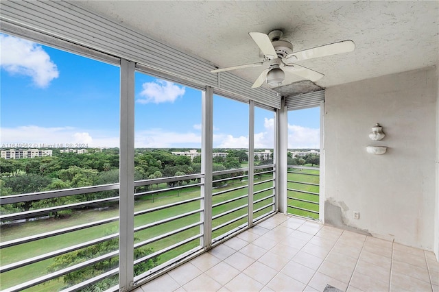 unfurnished sunroom with ceiling fan