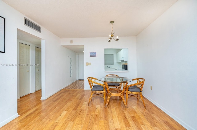 dining area with a notable chandelier and light wood-type flooring