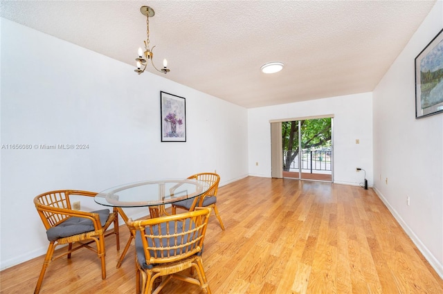 dining space with light wood-type flooring and a textured ceiling