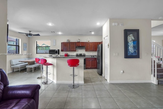 23841 SW 118th Pl, Homestead, FL 33032 - kitchen featuring under cabinet range hood, appliances with stainless steel finishes, a kitchen breakfast bar, open floor plan, and reddish brown cabinets