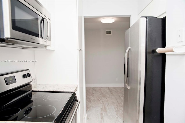 kitchen with light wood-type flooring and appliances with stainless steel finishes