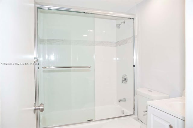 full bathroom with shower / bath combination with glass door, vanity, and toilet