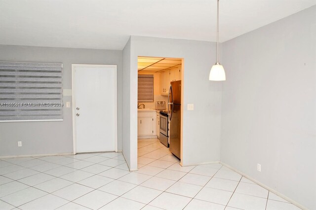 empty room featuring sink and light tile patterned floors