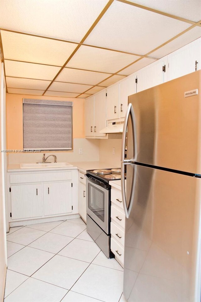 kitchen featuring white cabinets, appliances with stainless steel finishes, light tile patterned floors, and sink