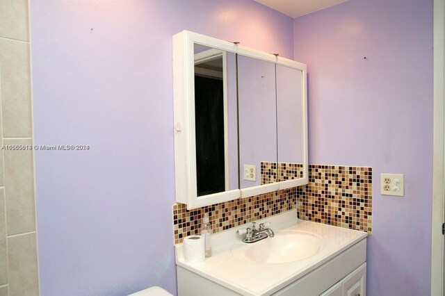 bathroom with vanity and tasteful backsplash