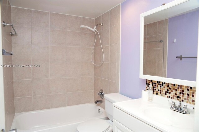 full bathroom with backsplash, toilet, tiled shower / bath combo, and vanity