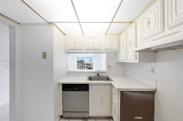 kitchen with white cabinets, tile countertops, premium range hood, stainless steel dishwasher, and sink