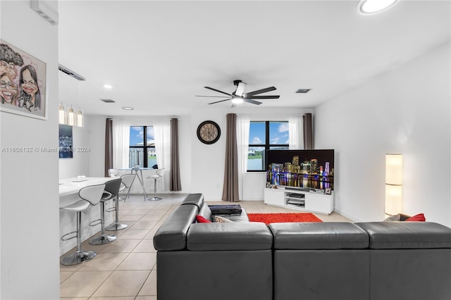 living room featuring ceiling fan, light tile patterned flooring, and a healthy amount of sunlight