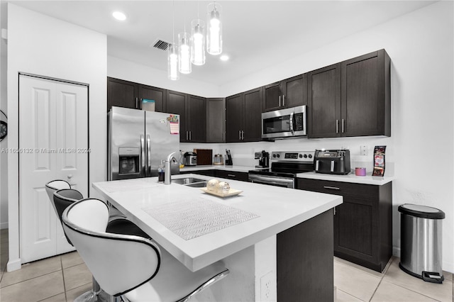 kitchen featuring appliances with stainless steel finishes, sink, a kitchen breakfast bar, and a center island with sink