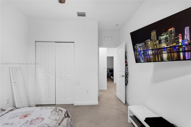 bedroom featuring vaulted ceiling, light colored carpet, and a closet