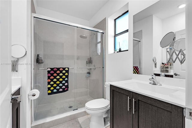 bathroom featuring a shower with shower door, tile patterned flooring, toilet, and vanity