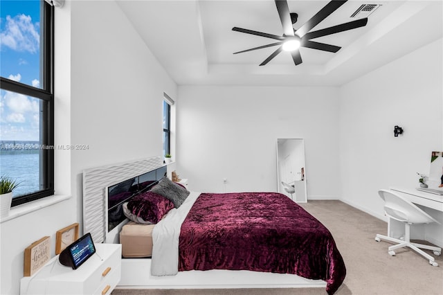 bedroom with light colored carpet, ceiling fan, and multiple windows