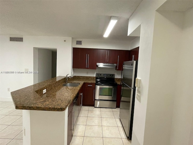 kitchen with appliances with stainless steel finishes, a textured ceiling, kitchen peninsula, and sink