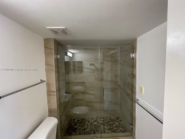 bathroom with a shower stall, visible vents, and toilet