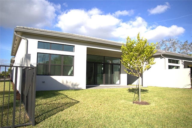 rear view of house featuring a lawn