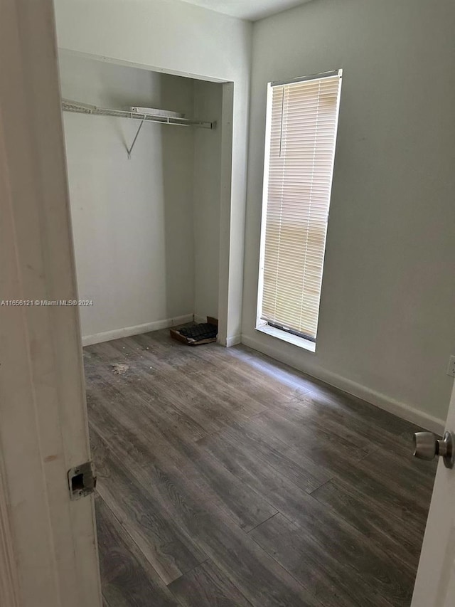 unfurnished bedroom featuring dark hardwood / wood-style floors and a closet