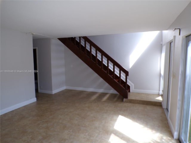 unfurnished living room featuring light carpet