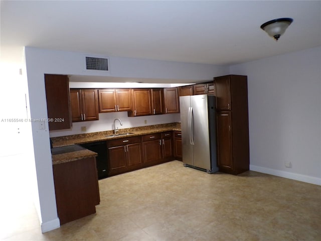 kitchen with dark brown cabinets, dishwasher, sink, and stainless steel fridge