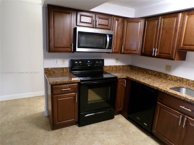 kitchen with dark stone countertops and black appliances