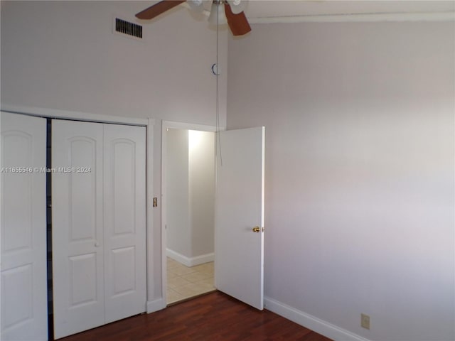 unfurnished bedroom with a closet, ceiling fan, and dark wood-type flooring