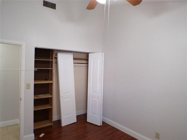 unfurnished bedroom with dark hardwood / wood-style floors, ceiling fan, and a closet