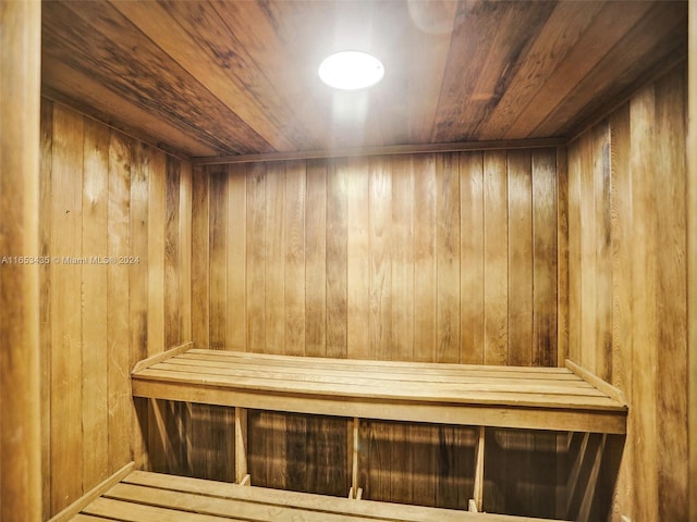 view of sauna with wooden ceiling and wooden walls