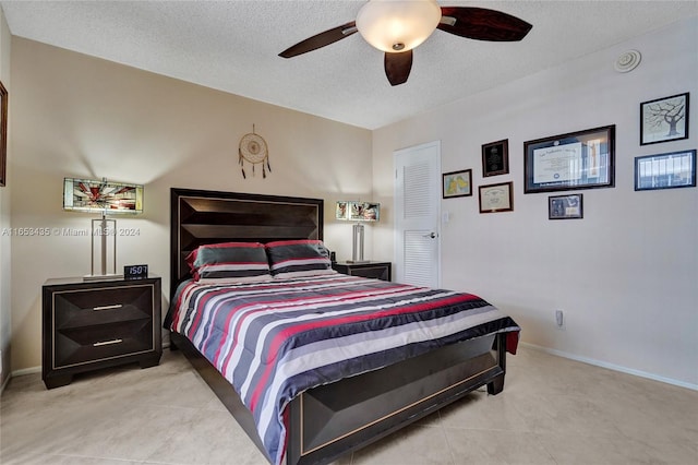 tiled bedroom featuring a textured ceiling and ceiling fan