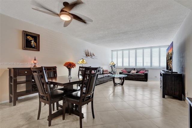 tiled dining space featuring ceiling fan and a textured ceiling