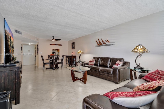 living room featuring a textured ceiling and ceiling fan