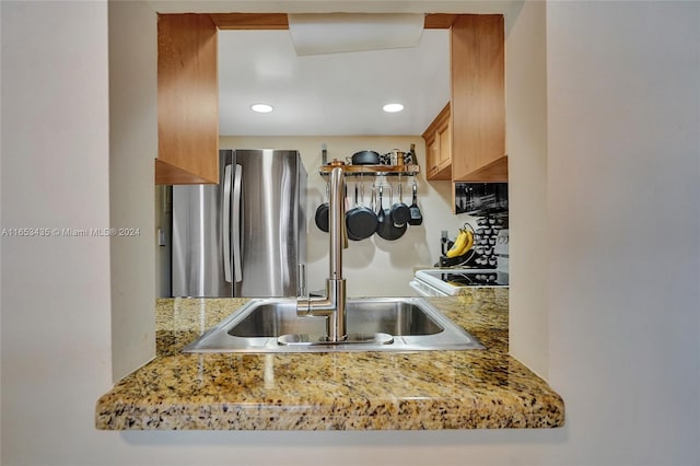 kitchen featuring white range with electric cooktop, stainless steel refrigerator, and sink