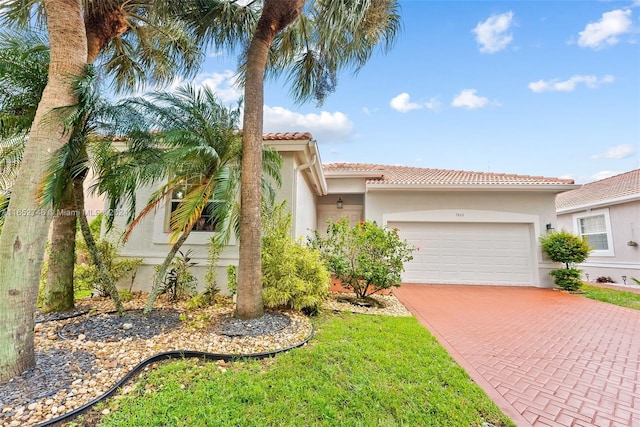 mediterranean / spanish home with a garage and a front lawn