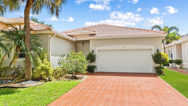 mediterranean / spanish house featuring a garage and a front lawn