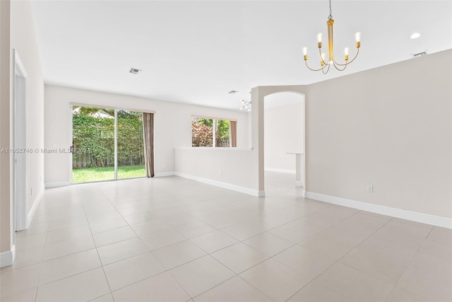 unfurnished room featuring a chandelier and light tile patterned flooring