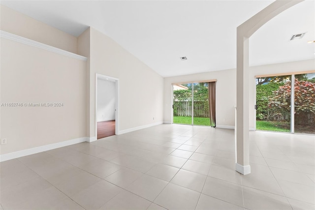 tiled spare room with vaulted ceiling