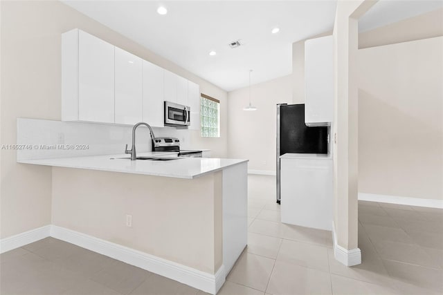 kitchen with appliances with stainless steel finishes, hanging light fixtures, kitchen peninsula, sink, and white cabinetry