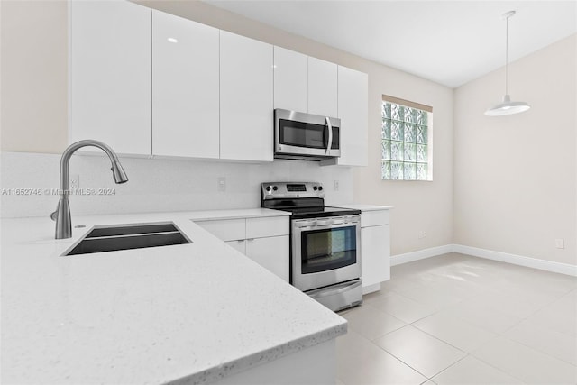 kitchen featuring sink, decorative light fixtures, appliances with stainless steel finishes, and white cabinets