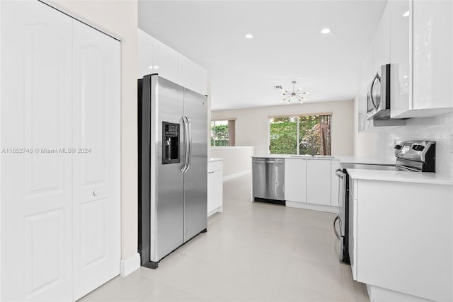 kitchen with stainless steel appliances, white cabinetry, and tasteful backsplash