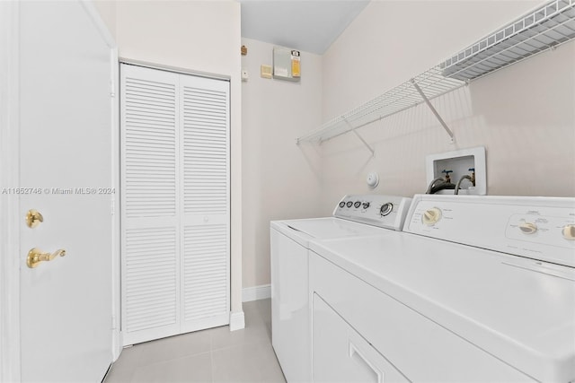 clothes washing area with light tile patterned floors and independent washer and dryer