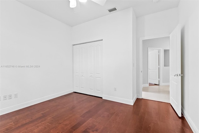 unfurnished bedroom with a closet, ceiling fan, and dark hardwood / wood-style floors