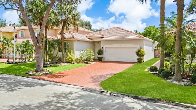 mediterranean / spanish-style home featuring a front lawn and a garage