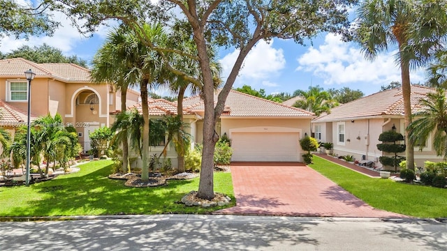 mediterranean / spanish-style home featuring a front yard and a garage