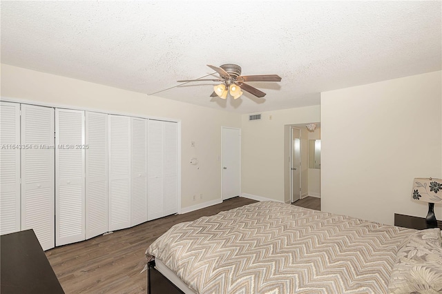 bedroom with a closet, visible vents, ceiling fan, a textured ceiling, and wood finished floors