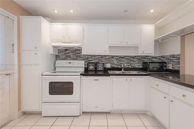 kitchen featuring dark countertops, white appliances, under cabinet range hood, and a sink