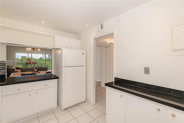 kitchen with freestanding refrigerator, white cabinets, visible vents, and dark countertops