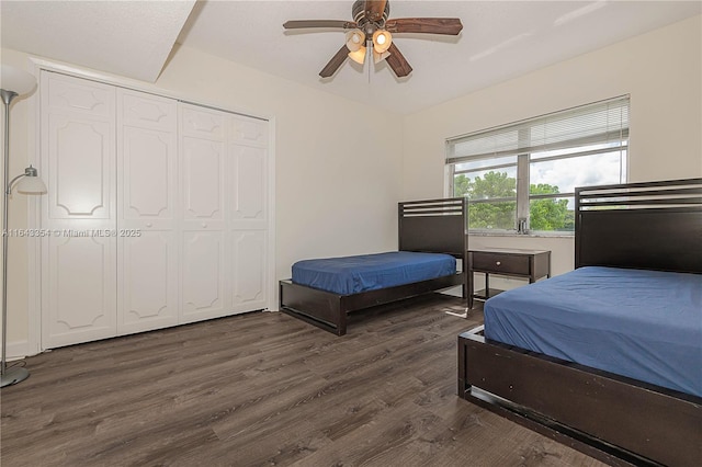 bedroom featuring dark wood-type flooring, a closet, and a ceiling fan