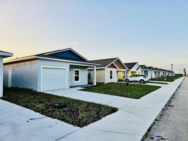 view of front of home with a garage, a residential view, a yard, and stucco siding