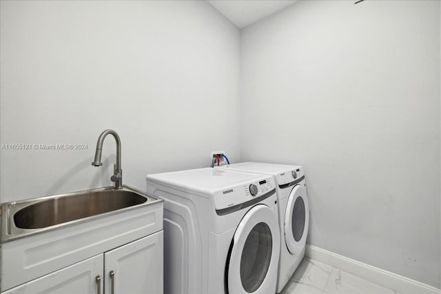 laundry room with washer and dryer, cabinets, and sink