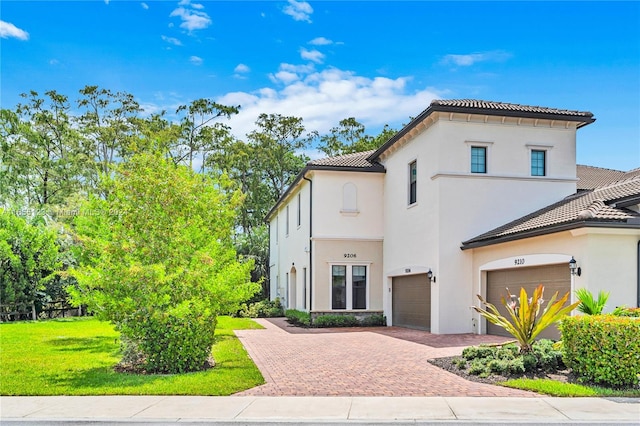 mediterranean / spanish house with a garage and a front yard